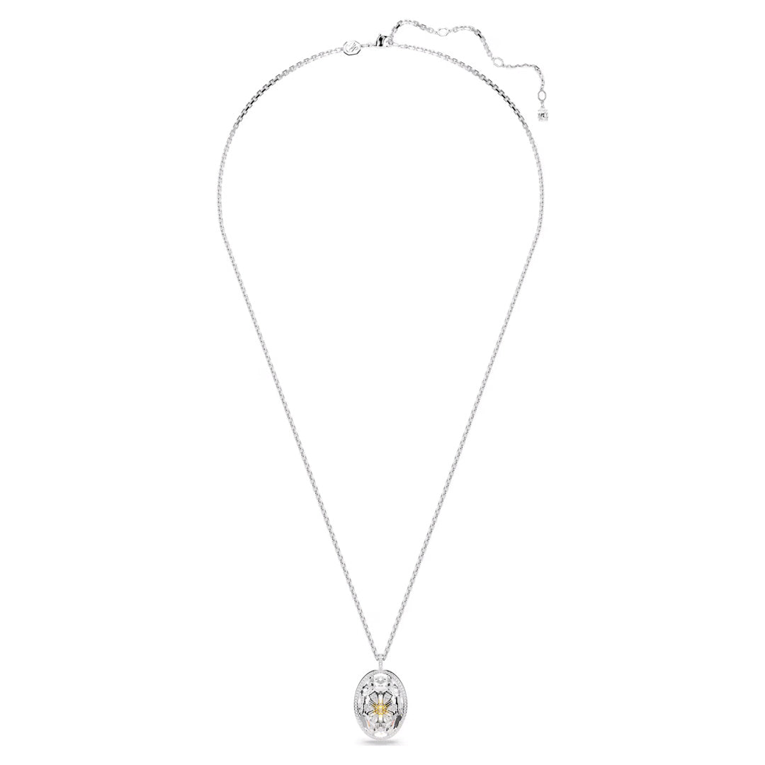 A Swarovski Idyllia Necklace Pendant, showcasing a large oval-shaped rhodium-plated pendant with a sparkling gemstone, is centered against a white backdrop. The pendant features intricate detailing around the gemstone, embodying the timeless elegance of Swarovski jewelry design.