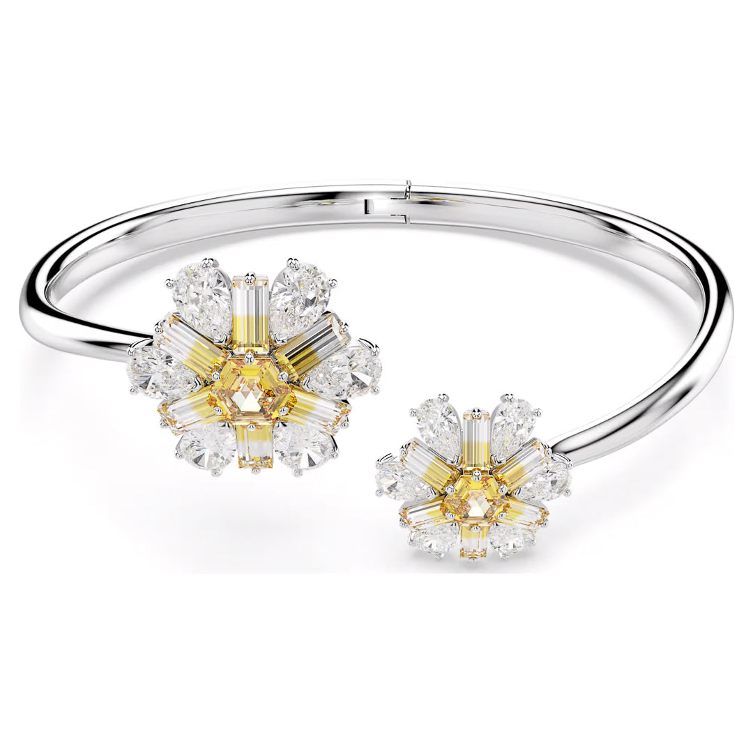 Introducing the Swarovski Idyllia Bangle: a stunning silver bracelet with rhodium-plated floral accents, crafted from radiant yellow and white Swarovski Zirconia. These floral designs, embellished with marquise and baguette-cut stones, impart an elegant and luxurious allure.