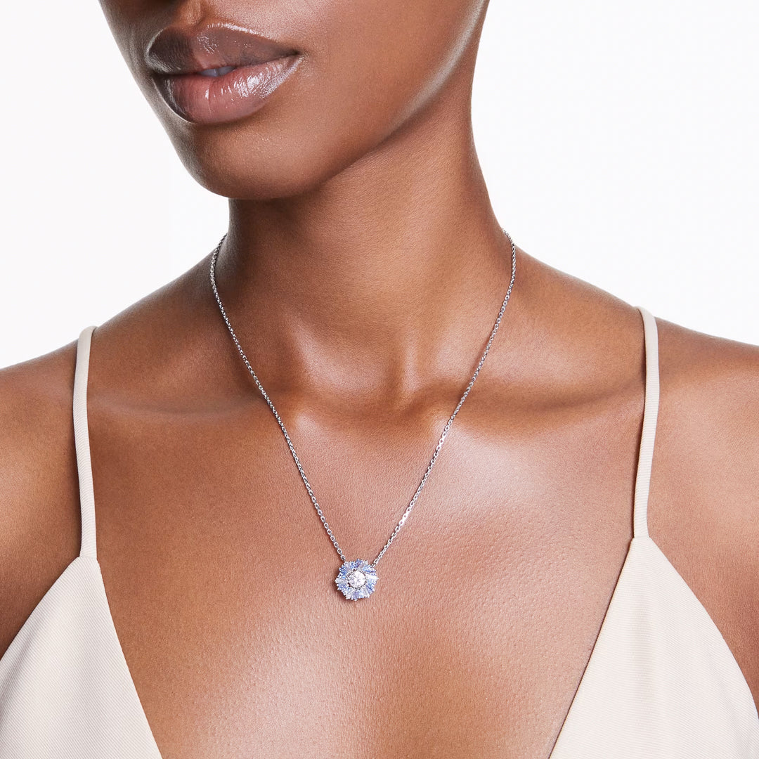 A person wearing a Swarovski Idyllia Necklace Pendant against a neutral-toned top, highlighting the sparkling jewelry and the upper torso.