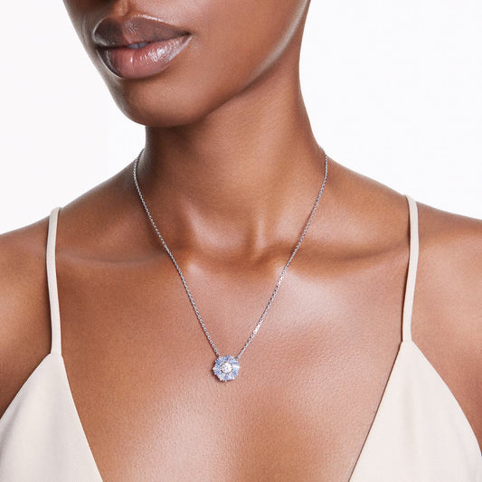 A person wearing a Swarovski Idyllia Necklace Pendant against a neutral-toned top, highlighting the sparkling jewelry and the upper torso.