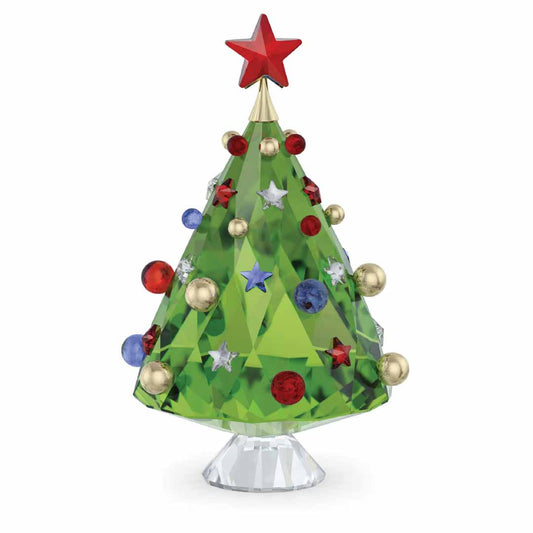 The Swarovski Holiday Cheers Tree Home Décor by Swarovski is a festive decorative piece featuring a green crystal holiday tree adorned with red, blue, and gold ornaments, all topped with a red star. This elegant centerpiece stands on a clear crystal base.