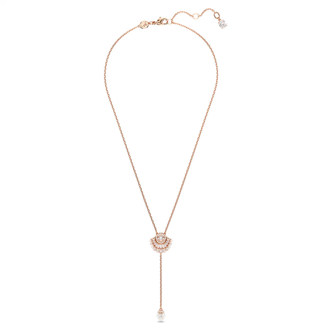 The Swarovski Idyllia Y Necklace Pendant by Swarovski is a delicate rose gold-tone plated necklace showcasing an ocean-inspired circular pendant with intricate designs, adorned with Swarovski Zirconia. A slender chain extends from the pendant, culminating in a single pearl at its tip.
