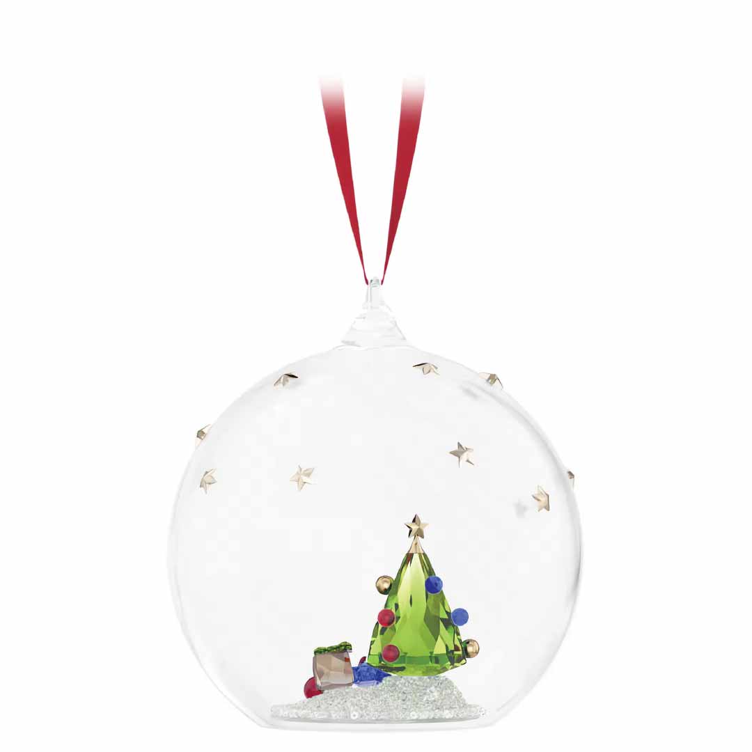 The Swarovski Holiday Cheers Tree and Gifts Ball Ornament by Swarovski features a clear glass design, similar to a crystal figurine, with a tiny green Christmas tree inside decorated with colorful ornaments. Enhanced with gold stars around the outer glass surface, this festive décor piece is completed with a red ribbon for convenient hanging.