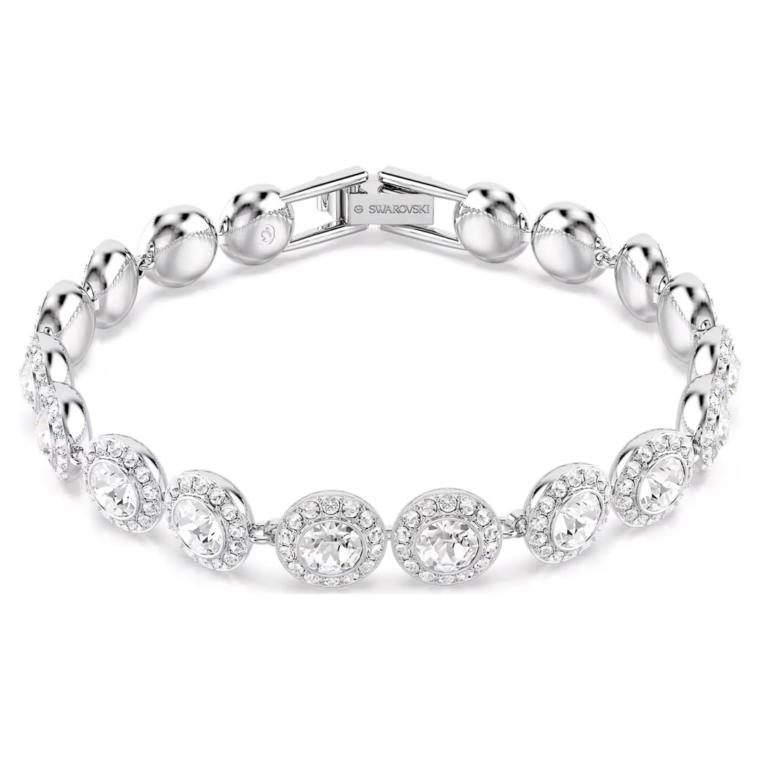 The Swarovski Una Angelic Tennis Bracelet, plated with rhodium for a polished finish, mesmerizes with its arrangement of round, glimmering stones and refined clasp. Its sophisticated design features a pattern of alternating large and small rhinestones that are beautifully complemented by a captivating central crystal, exuding an aura of luxury.
