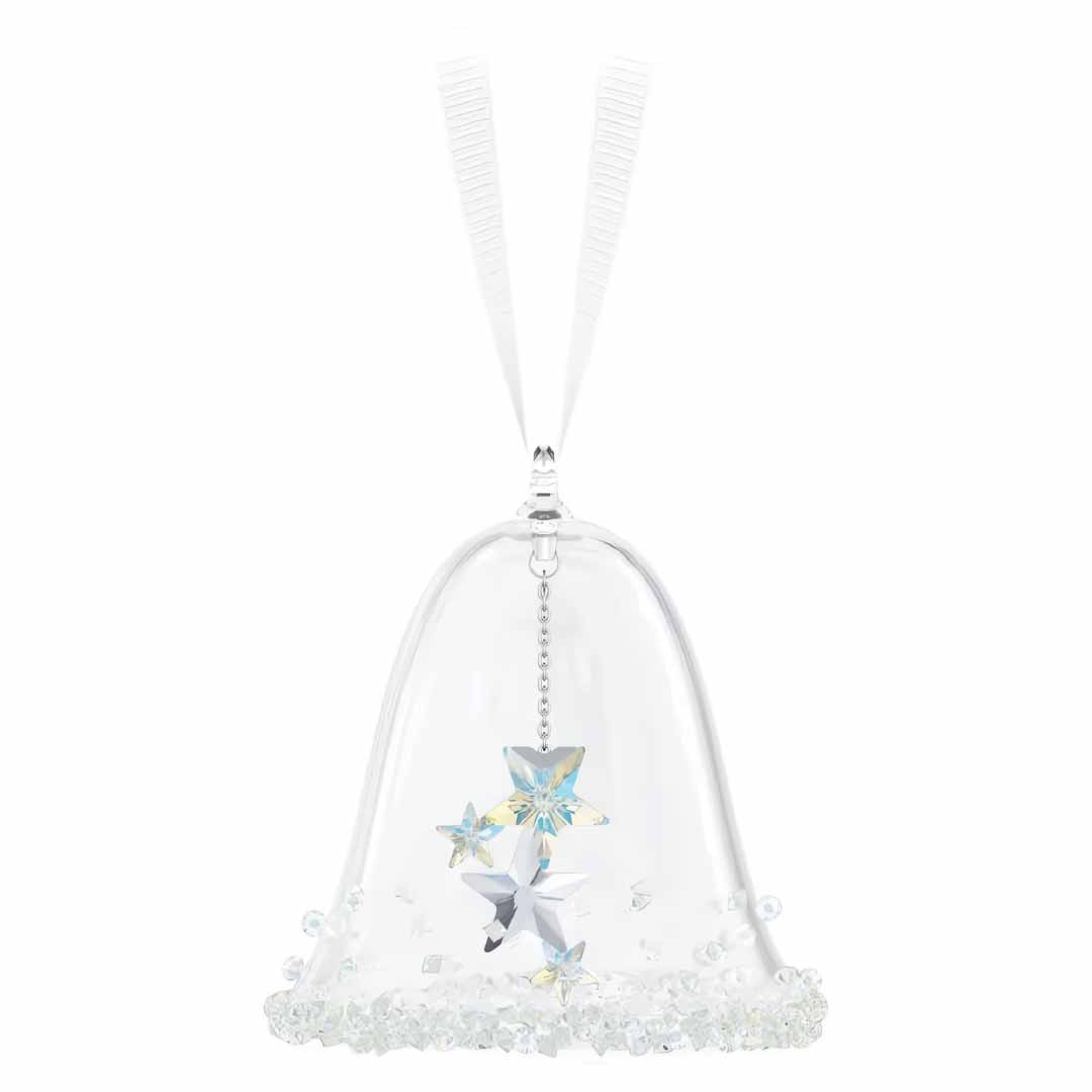 The Swarovski Holiday Magic Classic Bell Ornament from the renowned brand Swarovski boasts a lovely white ribbon hanger and exquisite star-shaped designs that reflect the Aurora Borealis effect. Its base is adorned with small, clear crystalline beads, introducing an air of elegance to your Holiday Magic Classics collection.
