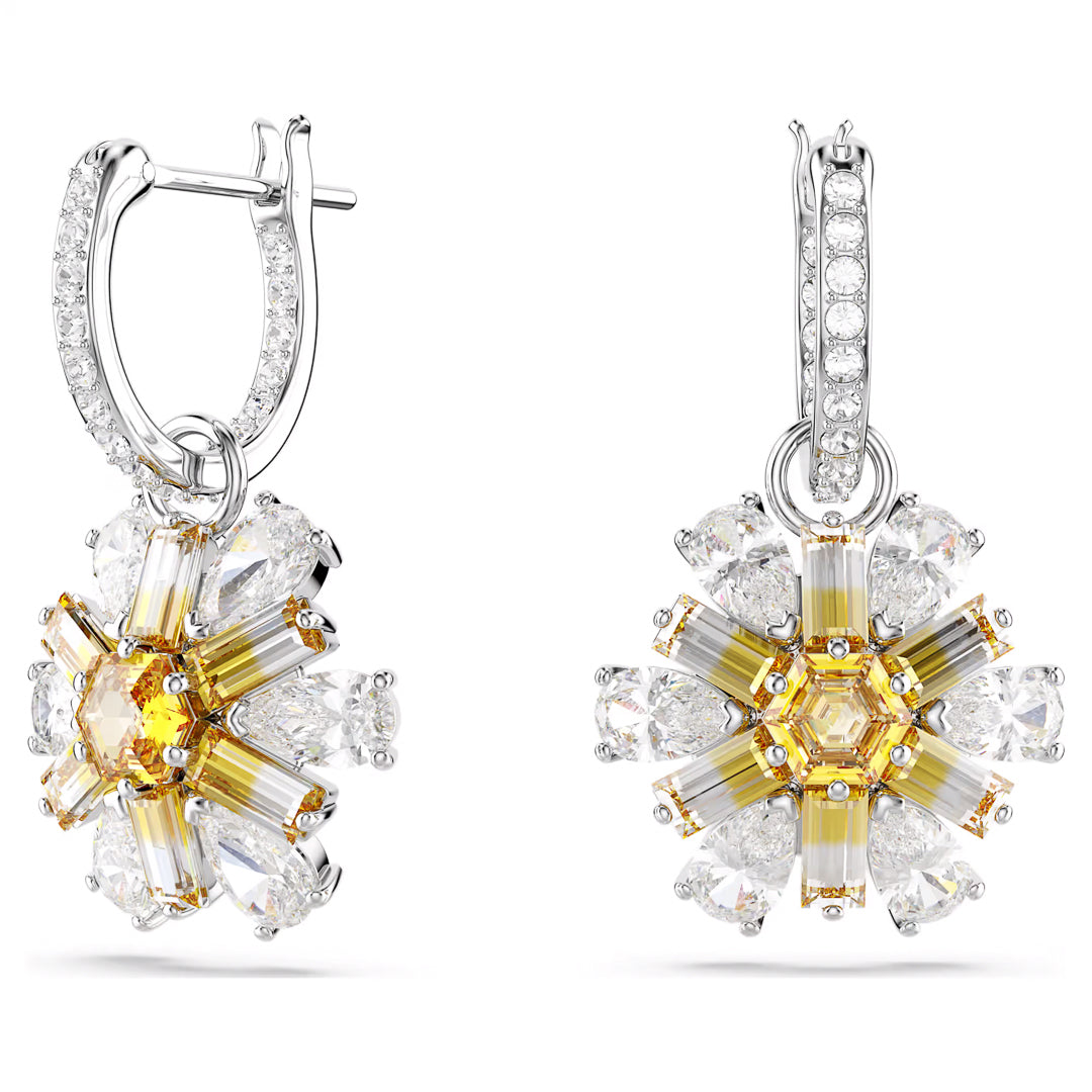 The Swarovski Idyllia Drop Earrings, crafted by Swarovski, feature an exquisite floral design. The petals are formed by elongated yellow Swarovski Zirconia stones and are beautifully encircled by teardrop-shaped clear stones. These elements are set in rhodium-plated silver hoops that are adorned with smaller clear gemstones.