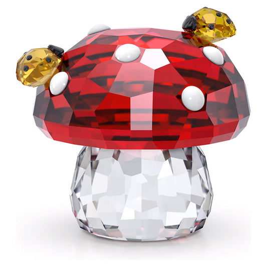 The Swarovski Idyllia Mushroom and Ladybugs Home Décor features a charming mushroom figurine embellished with two amber-colored ladybugs resting on a red and white spotted crystal base. Its faceted design accentuates the sparkling allure, making it an enchanting and dazzling addition to any collection.