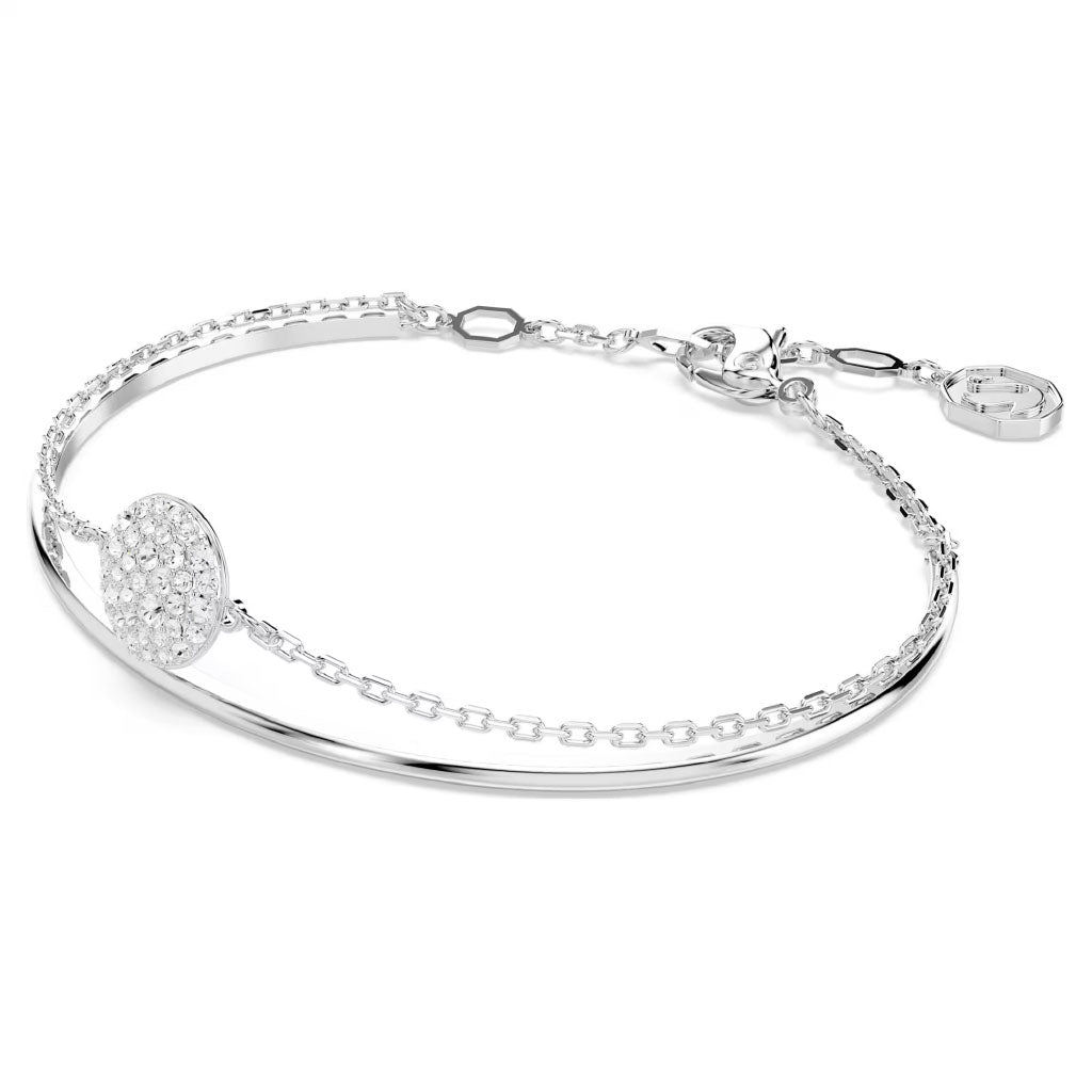 The Swarovski Sublima Bangle by Swarovski transforms a delicate silver bracelet with a thin chain and circular, crystal-embellished charm into a starry masterpiece with its sleek rhodium-plated design and small clasp.