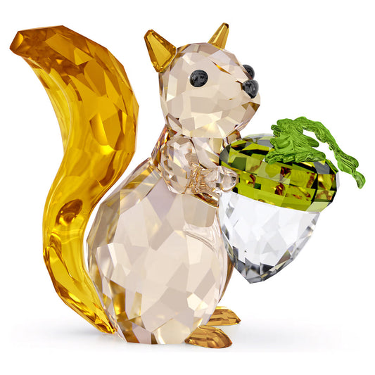 The Swarovski Idyllia Squirrel and Acorn Home Décor boasts a stunning crystal squirrel figurine, adorned with a golden tail and translucent body, clutching an acorn. This elegant ornament features an acorn with a clear base and green top that beautifully captures detailed craftsmanship while expertly reflecting light.