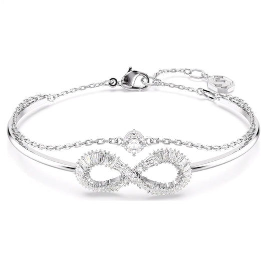 Introducing the Swarovski Hyerbola Bangle: a finely crafted bracelet by Swarovski, adorned with an infinity symbol embellished with small Swarovski Zirconia stones. This rhodium-plated silver piece features a delicate chain, accompanied by a secure clasp and an elegant charm. Its sophisticated design exudes elegance and class.