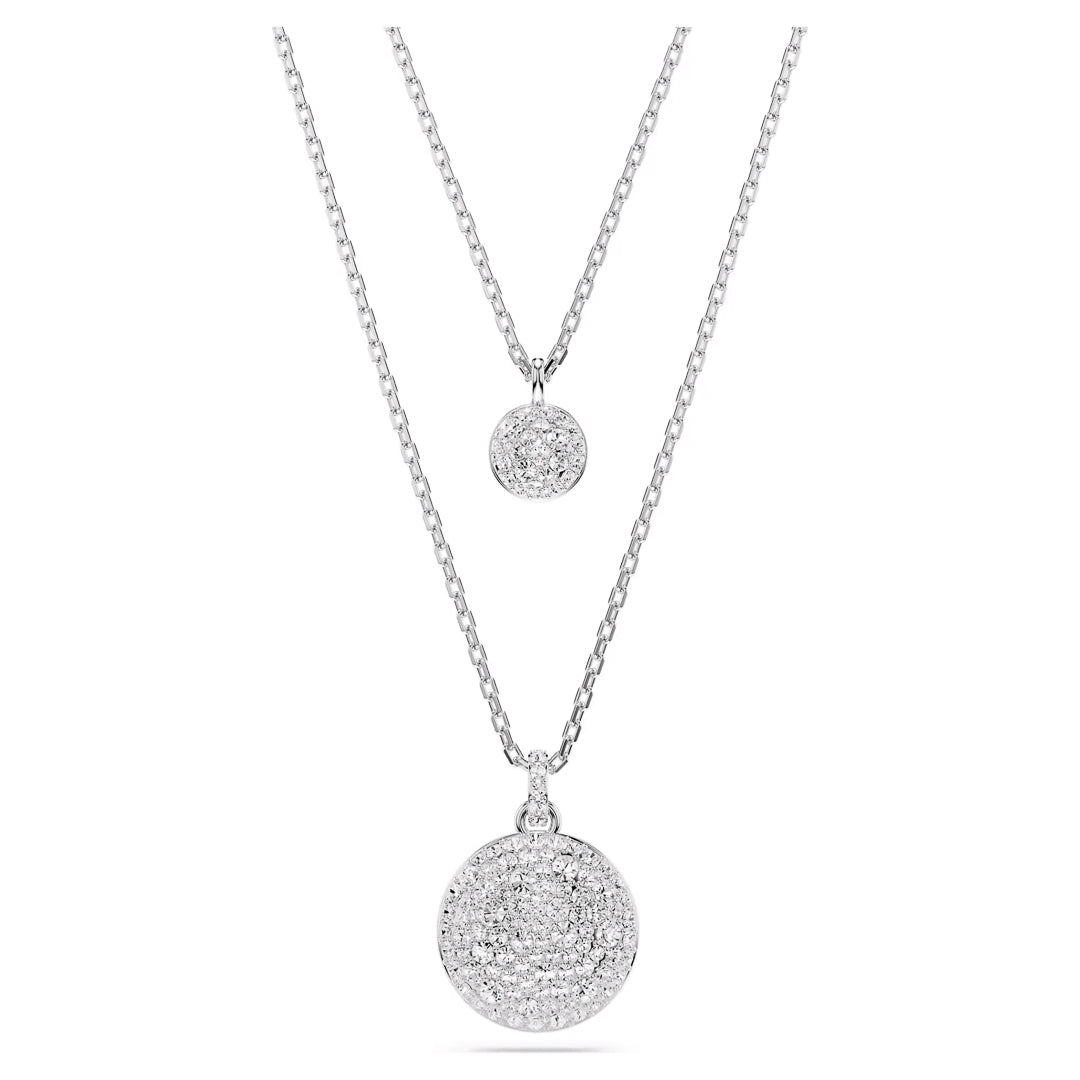 The Swarovski Sublima Layered Necklace Pendant by Swarovski showcases two silver necklaces with shimmering layered pendants adorned with round, crystal-studded accents. The larger pendant elegantly hangs from a slightly longer chain, both bearing a twisted rope design. The rhodium-plated finish adds an extra touch of elegance to the sparkling stones.