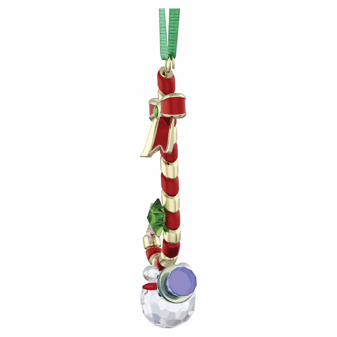 Enhance your decor with the Swarovski Holiday Cheers Dulcis Candy Cane Ornament. This stunning piece showcases a crystal snowman wearing a purple hat, elegantly suspended from a candy cane adorned with a red ribbon. With its green string, this crystallized ornament by Swarovski adds festive charm to any space.