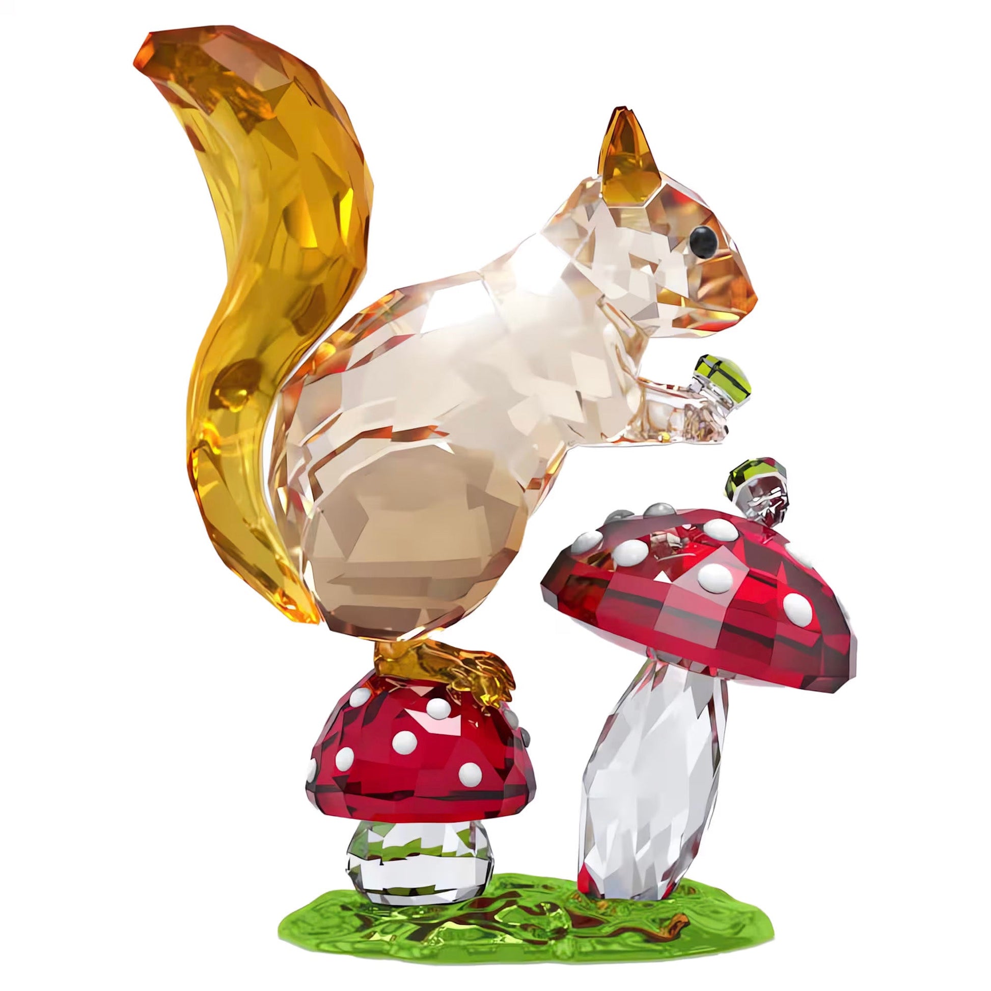 From the Swarovski Idyllia collection, the Squirrel and Mushrooms home décor piece captivates with its crystal embellishments. The squirrel perches on red and white spotted mushrooms, clutching a small green acorn, while its golden tail glistens atop a glossy green base that resembles grass.