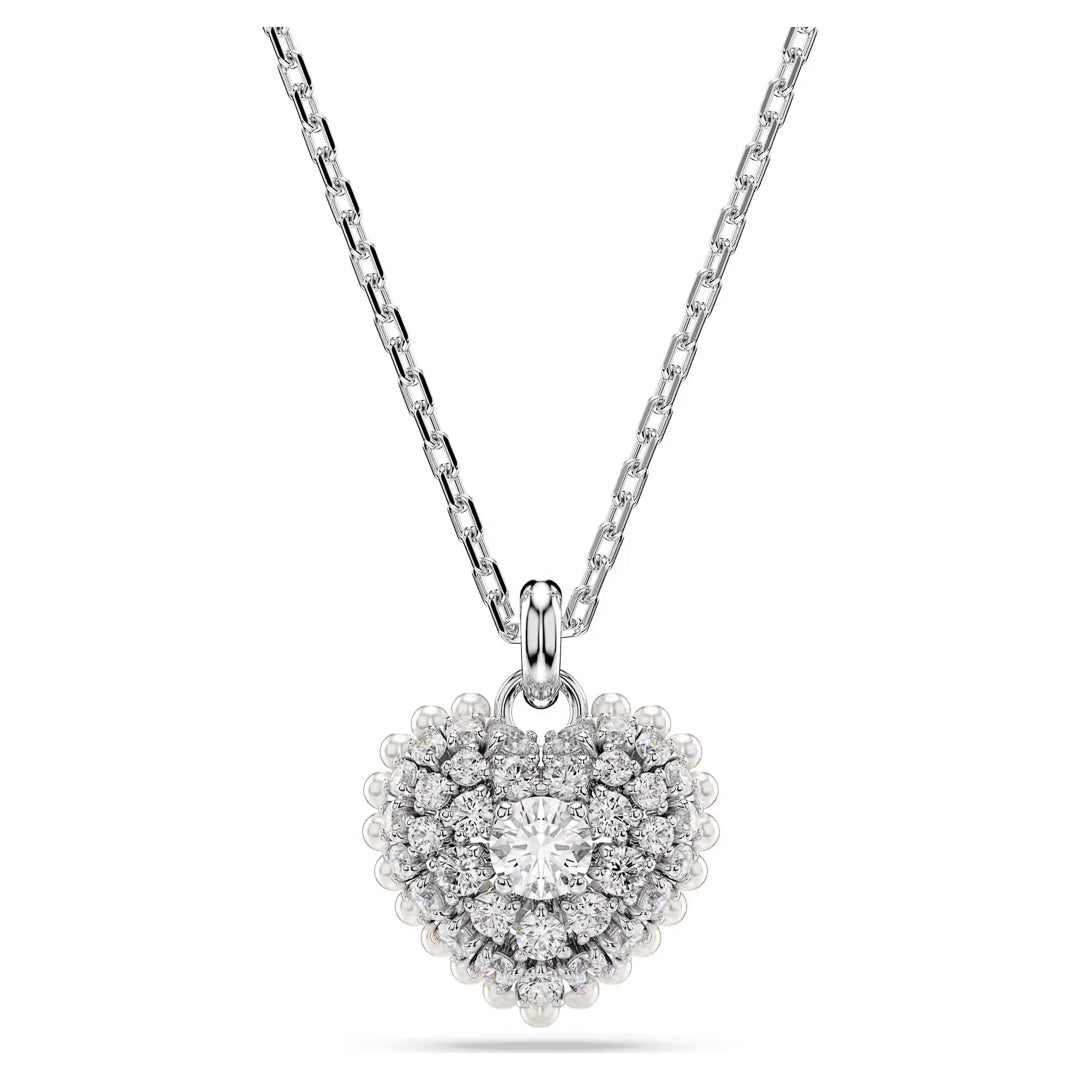 Introducing the Swarovski Idyllia Heart Necklace Pendant by Swarovski, a breathtaking silver necklace that showcases a heart-shaped pendant adorned with sparkling Swarovski Zirconia around a larger central diamond. The delicate chain, featuring evenly spaced links, enhances the elegance of this exquisite piece.