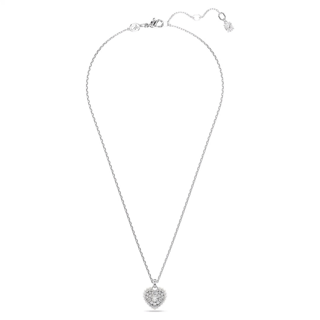 The Swarovski Idyllia Heart Necklace Pendant by Swarovski showcases a delicate silver heart-shaped pendant embellished with dazzling Swarovski Zirconia. It gracefully hangs from a fine chain with an adjustable clasp, and the white background accentuates its elegant and refined design.