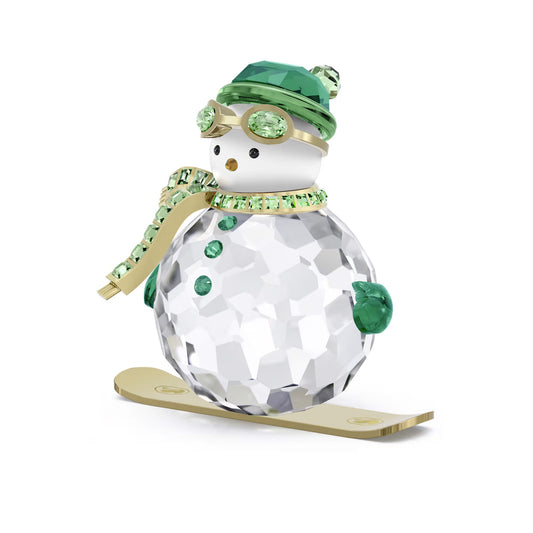The Swarovski Holiday Cheers Dulcis Snowman Home Décor, crafted by Swarovski, is an ideal holiday decoration. This exquisite figurine features a clear crystal snowman adorned with a green hat, scarf, and goggles. It also wears green mittens and stands gracefully on gold skis. The beautifully faceted body enhances the sparkle of the clear crystal.