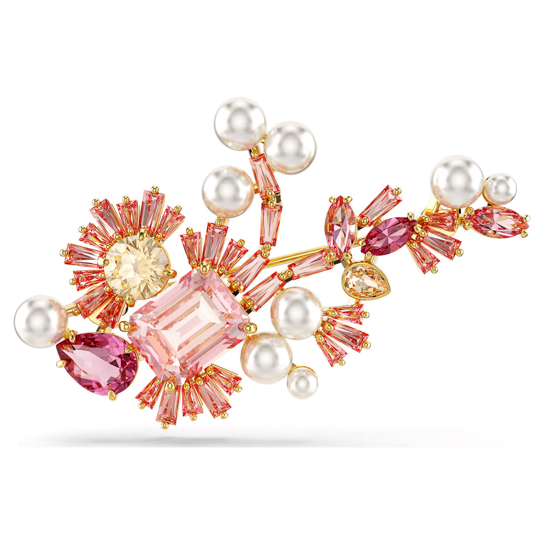 Introducing the Swarovski Gema Brooch by Swarovski, a jeweled masterpiece featuring pink and clear Swarovski Zirconia alongside shimmering crystal pearls. Set in a gold-colored frame, the design resembles an abstract floral pattern with a mix of oval, marquise, and rectangular shapes.