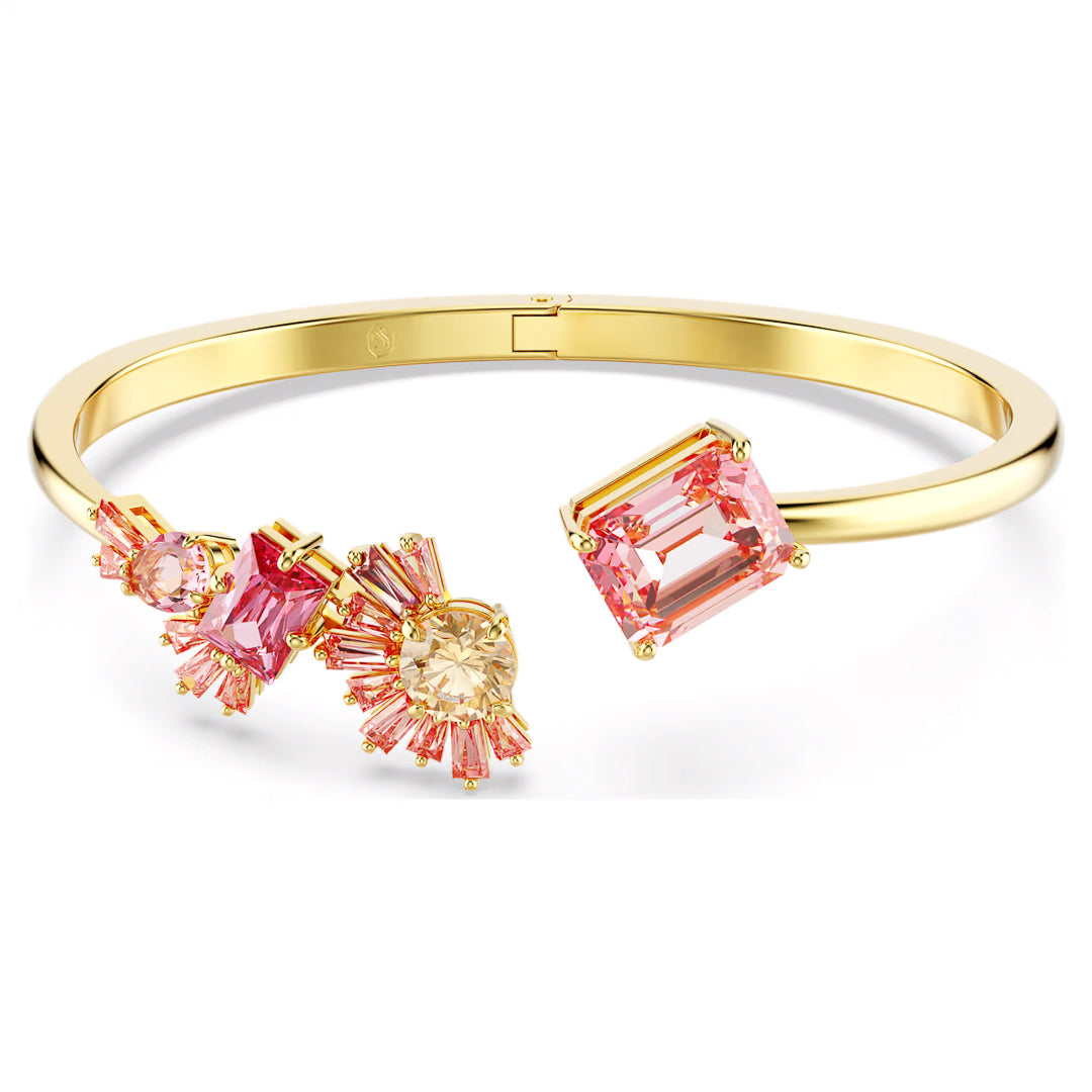 Swarovski's Gema Bangle features a striking large rectangular pink gemstone on one end and three distinctive cluster designs adorned with Swarovski Zirconia in pink and peach tones on the other, creating a lively and sophisticated cherry blossom-inspired look.