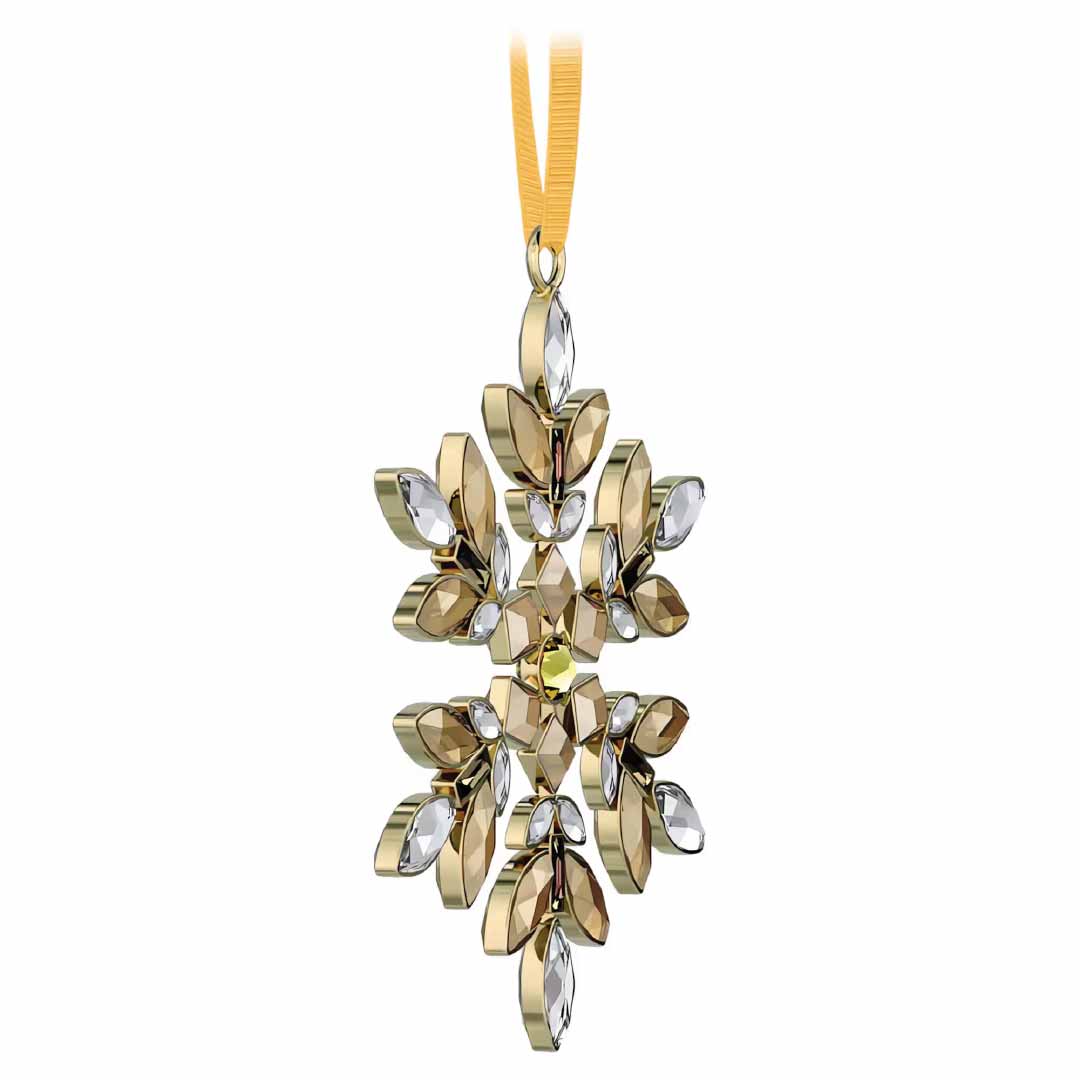 Swarovski's Gema Holiday Ornament Home Décor is a gold and silver snowflake adorned with a ribbon. This exquisite piece boasts an intricate design featuring gleaming metal and crystal-like accents, capturing the elegance of the Swarovski brand for a festive holiday season.