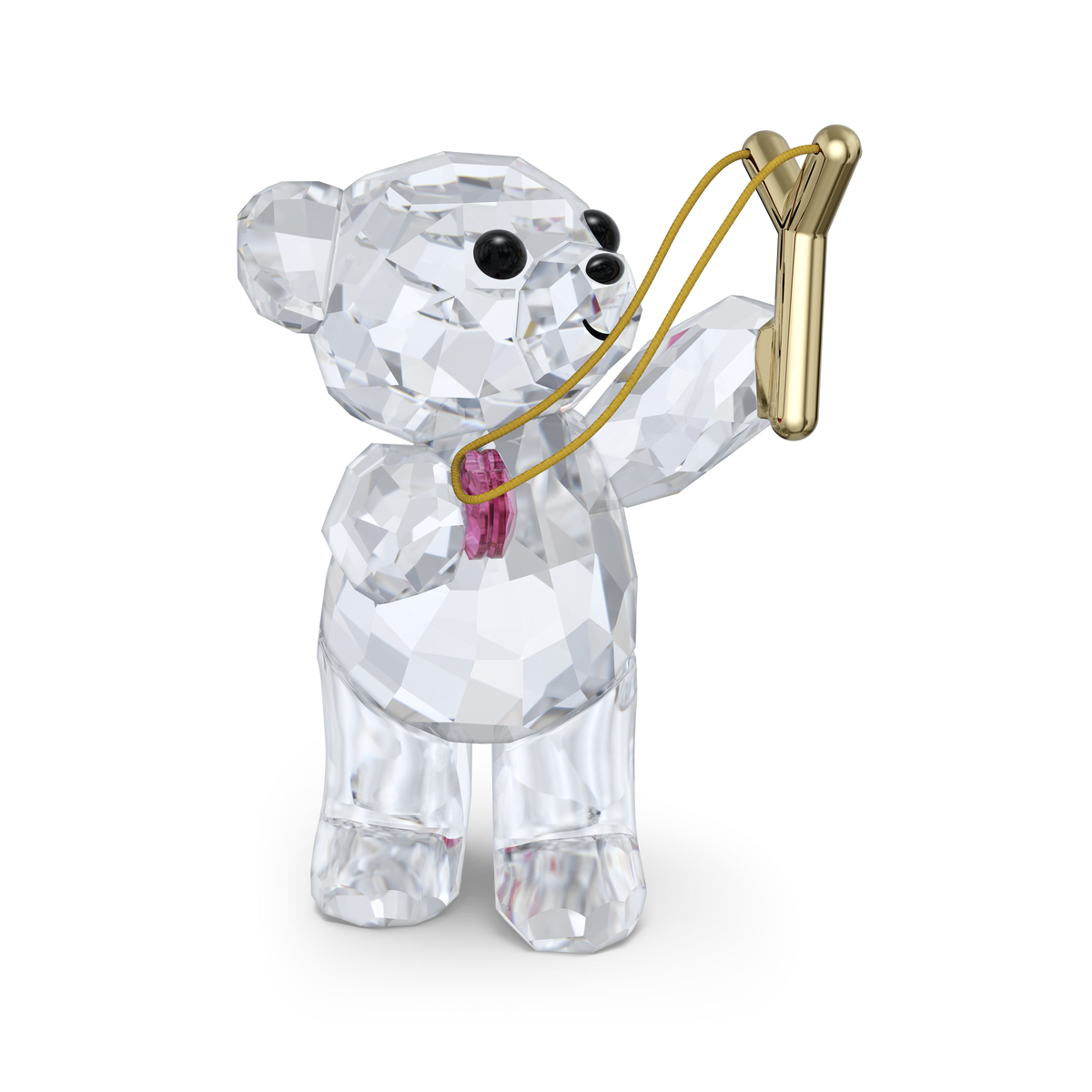 The Swarovski Kris Bear Sending you Love by Swarovski is a charming clear crystal bear figurine with sparkling faceted surfaces, black eyes, and a pink bow, holding a gold slingshot. Ideal as a Valentine’s Day gift or collectible, this adorable design stands out beautifully against a plain white background.