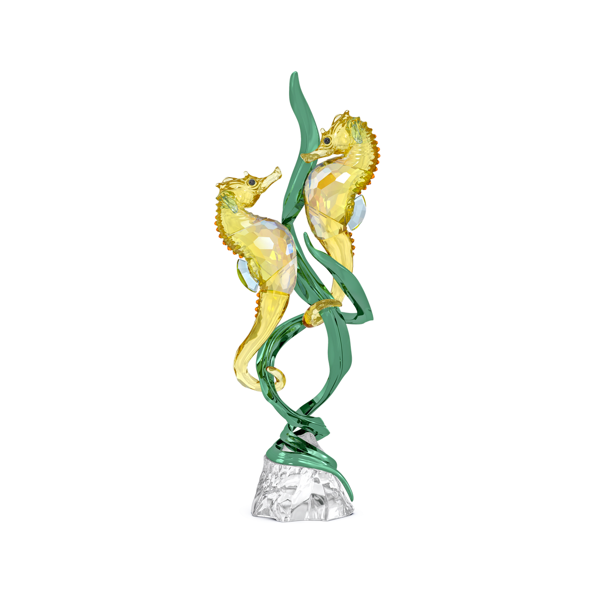 Two yellow crystal seahorses face each other, entwined around green crystal seaweed on a clear crystal base, against a plain white background. This exquisite piece is the Swarovski Idyllia SCS Annual Edition 2025 Seahorses, capturing the elegance synonymous with the Swarovski brand.