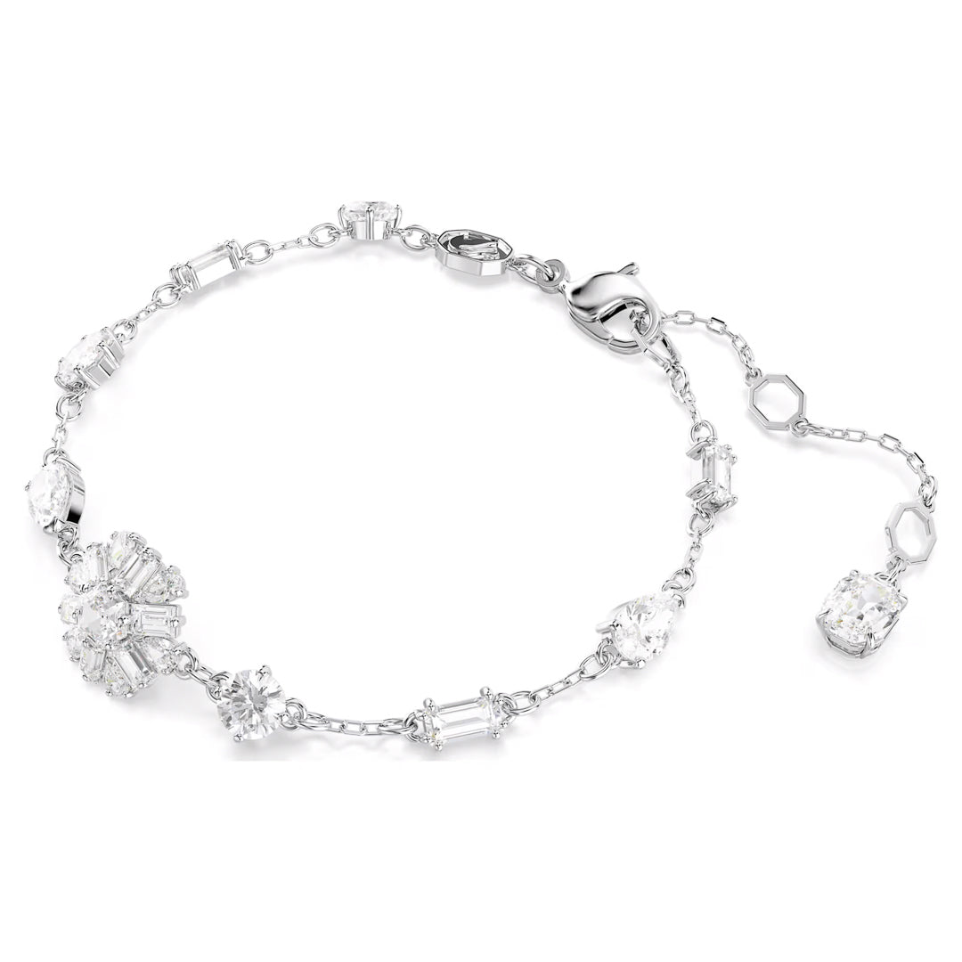 The Swarovski Idyllia Bracelet, crafted by Swarovski, is a delicate rhodium-plated silver accessory adorned with clusters and single settings of Swarovski Zirconia. It features a lobster clasp and an adjustable chain, beautifully echoing a subtle snowflake motif.