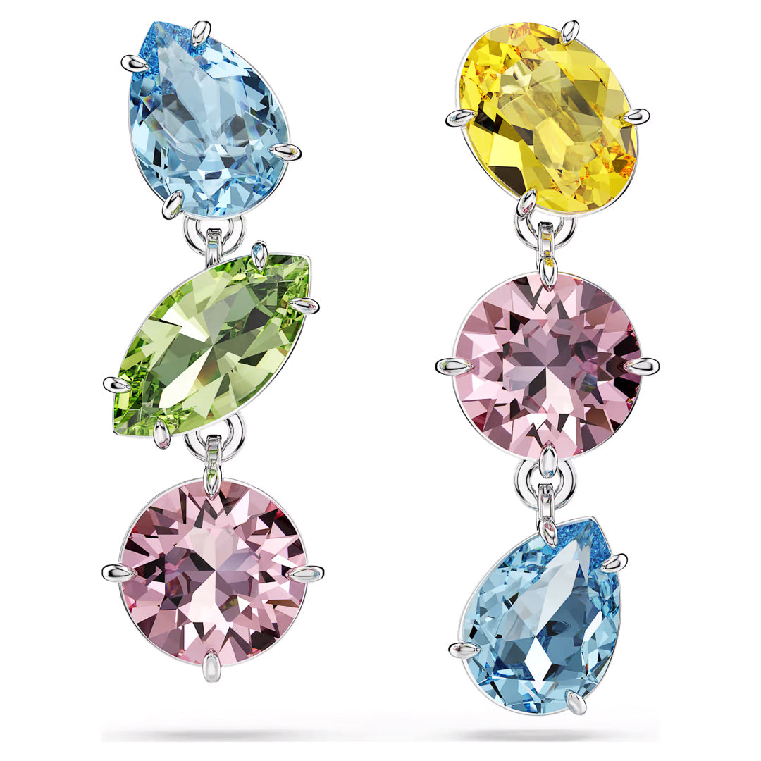 The Swarovski Gema Multicoloured Drop Earrings by Swarovski showcase vibrant gemstone pierced earrings adorned with varied crystals: one earring features a teardrop-shaped blue gem, a marquise-cut green gem, and a round pink gem, while the other includes a yellow gem, round pink crystal, and blue teardrop gem. These earrings are rhodium-plated for enhanced elegance.