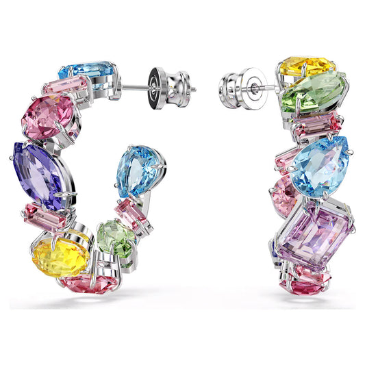 Discover the Swarovski Gema Multicoloured Hoop Earrings, featuring a vibrant array of gemstones in shades of pink, blue, green, purple, and yellow crystals beautifully set in silver. Each uniquely cut gem—oval, pear, and baguette—adds to the stylish charm of this dazzling accessory.