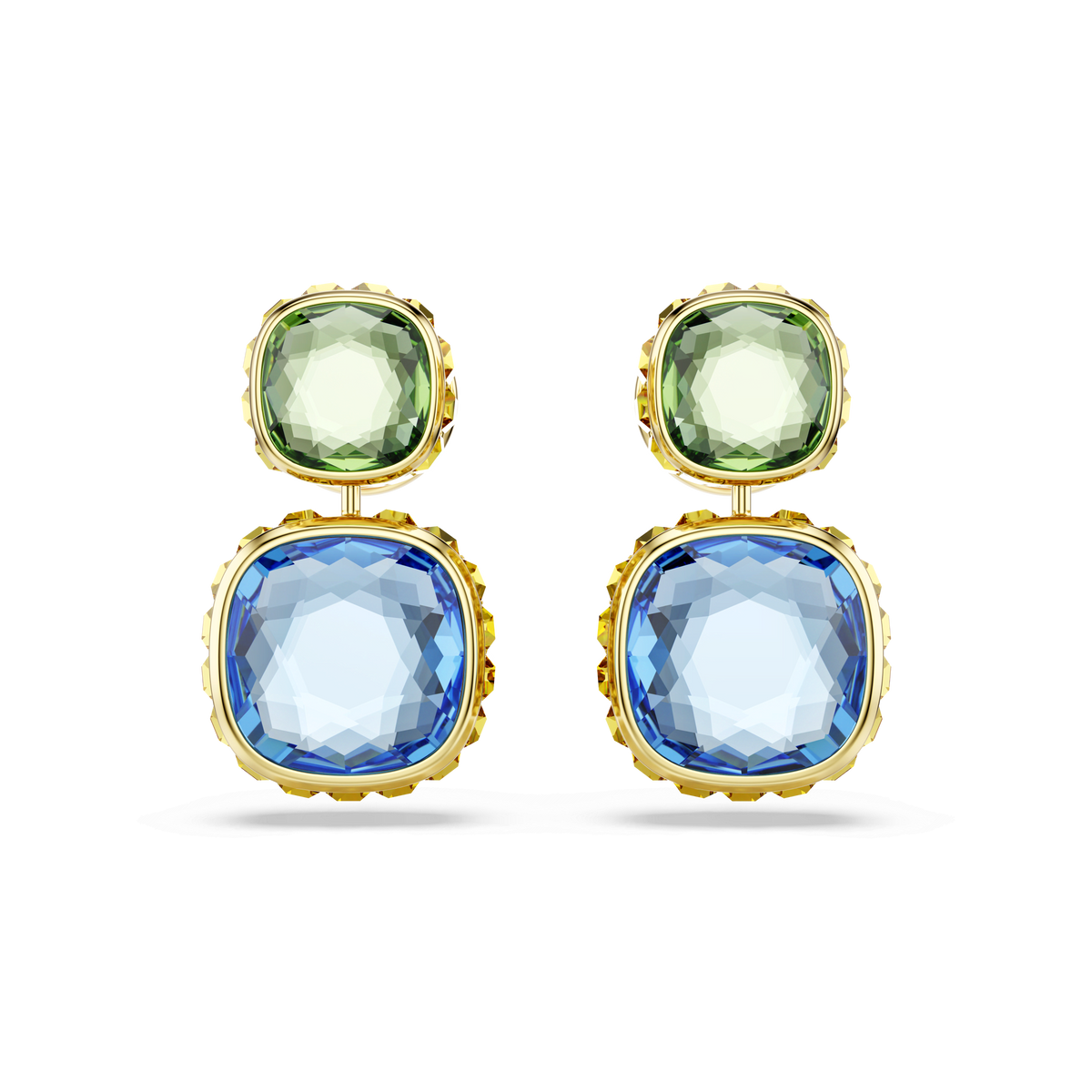 Swarovski Chroma drop earrings feature cushion-cut, multicolored stones set in 18K gold-finished bezels. A small, faceted light green gemstone rests above a larger, square blue Swarovski ReCreated crystal, both showcasing the signature brilliance of Chroma Twist jewelry. Displayed against a plain white background.