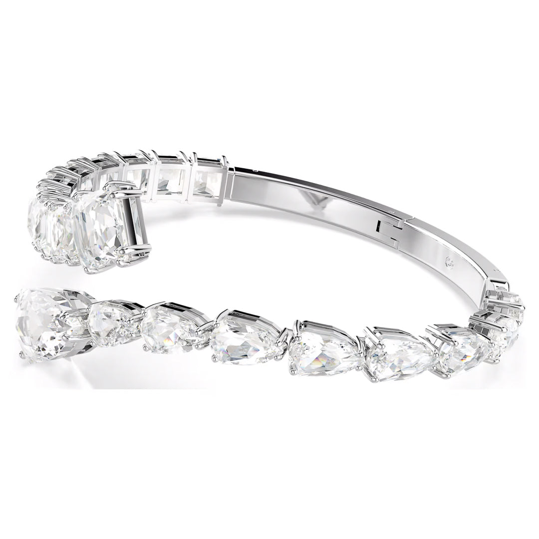 Close-up of the Swarovski Matrix Cuff, an elegant silver bracelet by Swarovski, featuring large, pear-shaped clear gemstones. The rhodium-plated cuff is open, showcasing its reflective surface and intricate gemstone arrangement on a plain white background.
