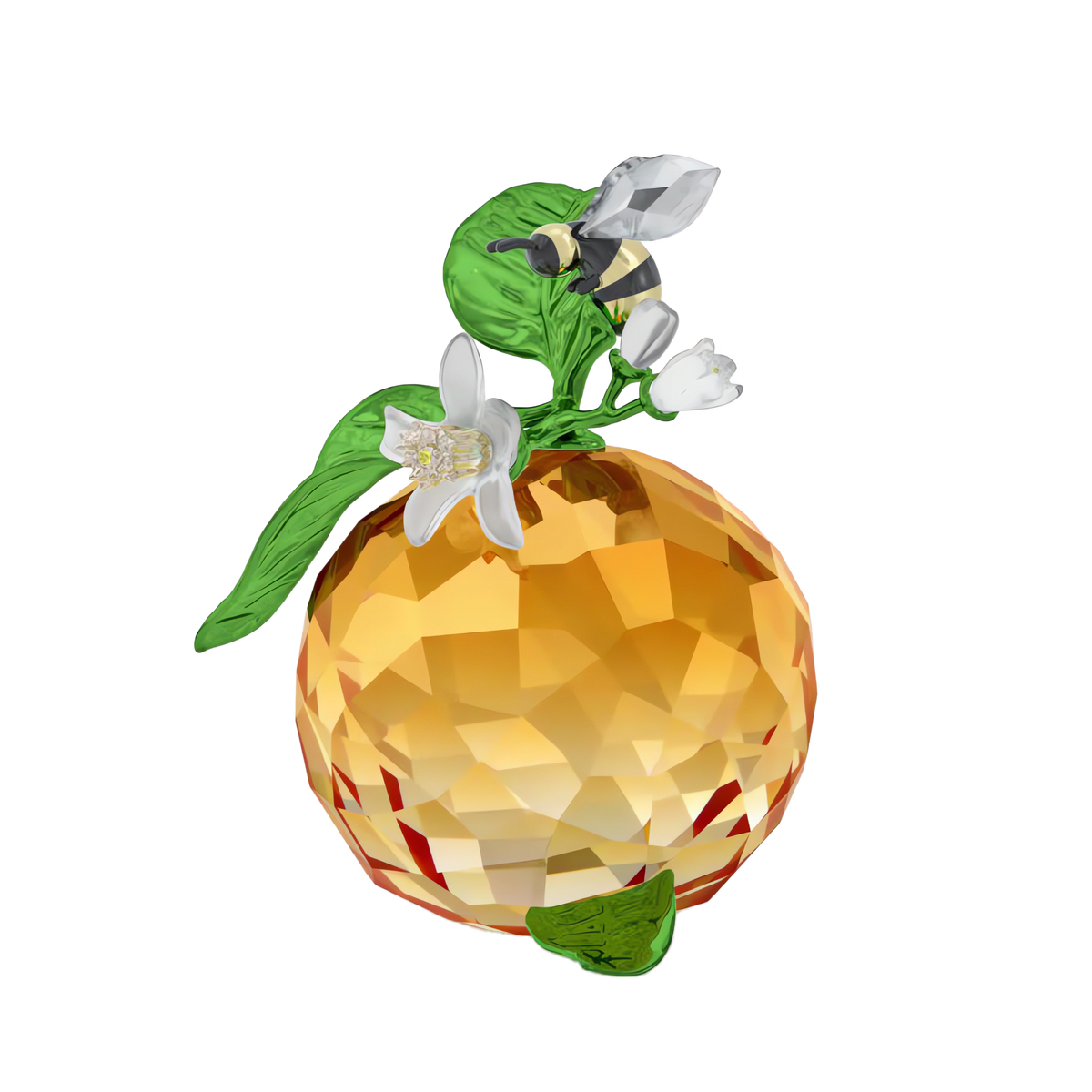The Swarovski Idyllia Clementine and Bee by Swarovski features a faceted orange crystal clementine adorned with green leaves and white flowers, topped with an intricately crafted Idyllia crystal bee figurine, displayed against a white background.