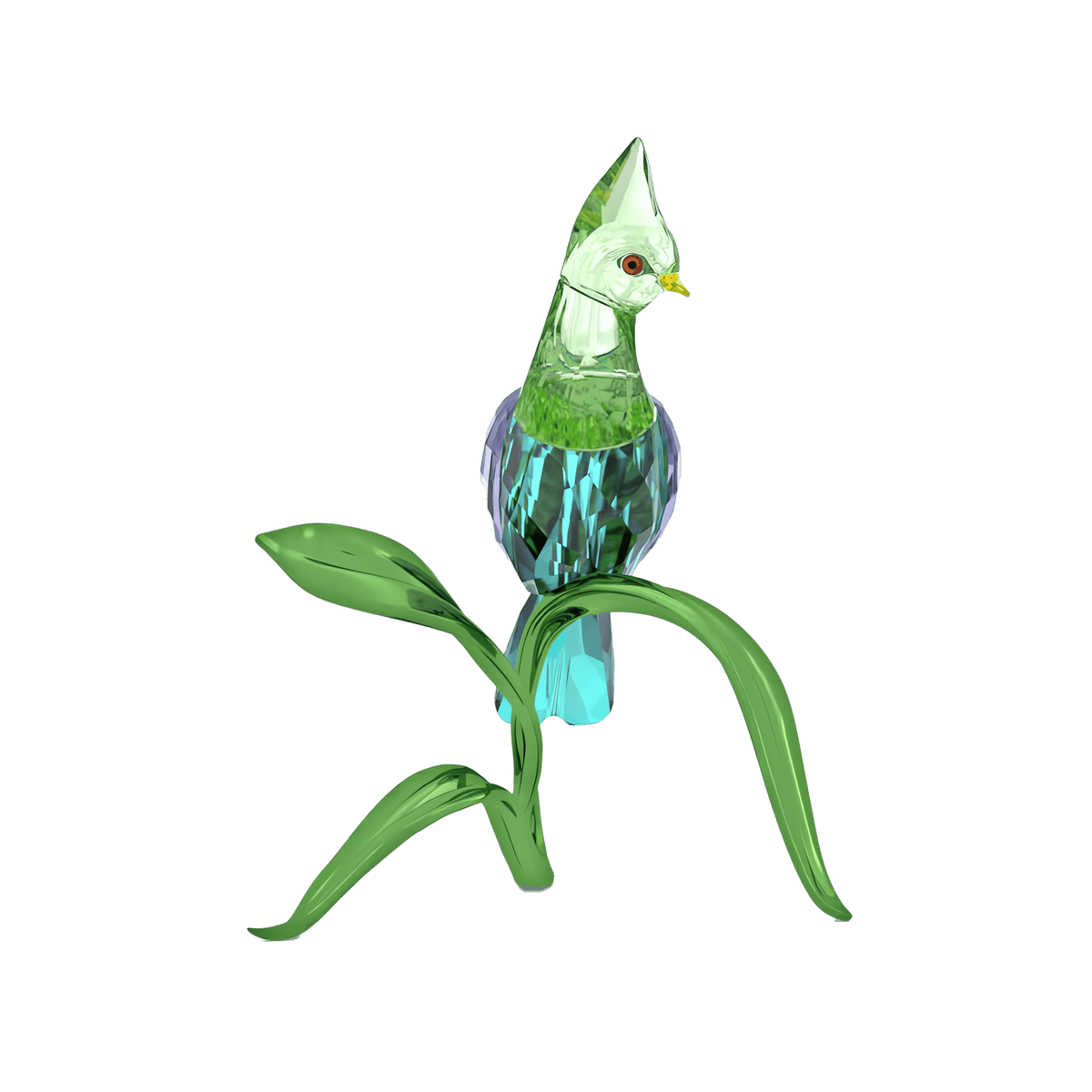 The Swarovski Idyllia Green Turaco by Swarovski features a green and blue glass bird with a yellow beak perched on a curved green glass branch adorned with two leaves, set against a plain white background—an elegant crystal figurine ideal for home decoration.