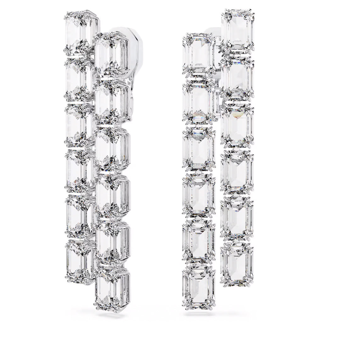 Introducing the Swarovski Millenia Clip Earrings by Swarovski, a sophisticated accessory showcasing two vertical rows of rectangular, emerald-cut diamonds elegantly set in polished metal with rhodium plating. The cascading design offers a luxurious and sparkling effect, ideal for those who admire a statement style.