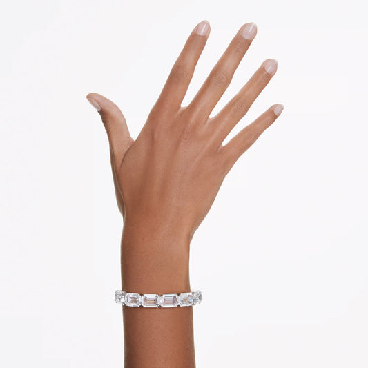 A hand is displayed wearing the exquisite Swarovski Millenia Bangle, showcasing octagon-cut crystals in an elegant silver setting against a plain white background.