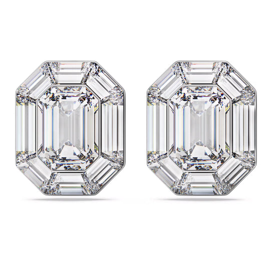 The Swarovski Lucent Clip Earrings feature two dazzling emerald-cut diamonds positioned side by side. Each diamond showcases a classic rectangular shape, echoing an octagon-cut design with beveled corners and step facets that enhance their clarity and brilliance. The earrings are beautifully presented on a plain white background.