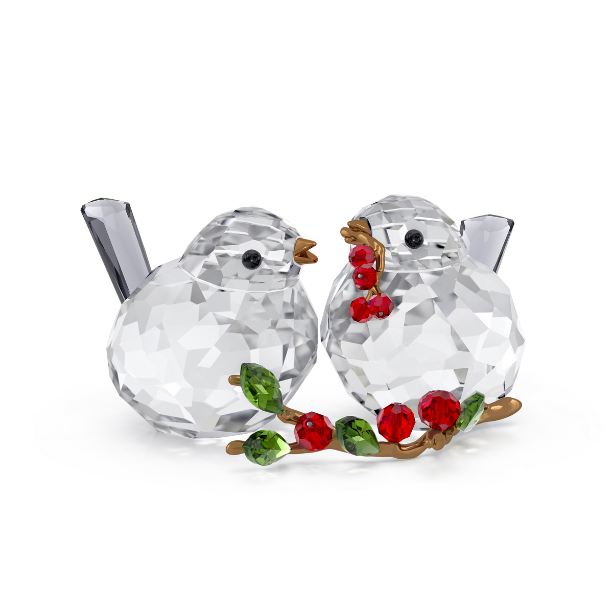 Two Swarovski Idyllia Bird Couple and Berries figurines face each other, with one holding a branch adorned with red crystal berries and green leaves. Both feature faceted bodies and tails, set against a plain white background—a charming Swarovski decoration that brings elegance to any space.