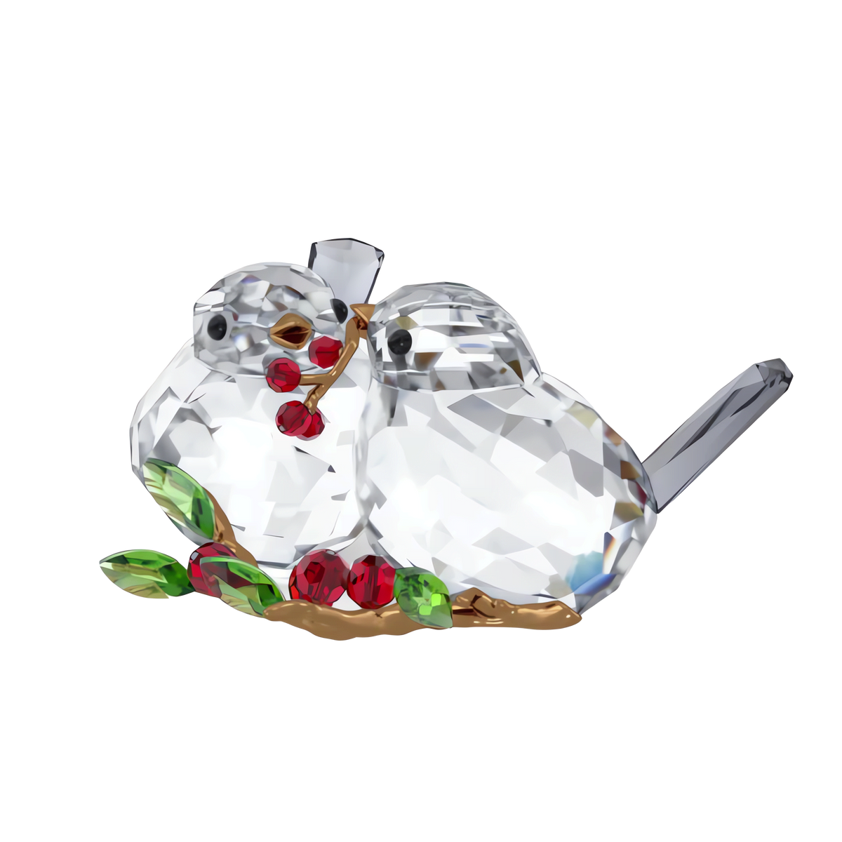 The Swarovski Idyllia Bird Couple and Berries by Swarovski features two crystallized birds sitting close together, with one holding red berries in its beak. Lush green leaves and additional berries rest beside them, evoking the tranquil charm of an Idyllia garden scene. The sparkling sculpture stands out beautifully against a white background.