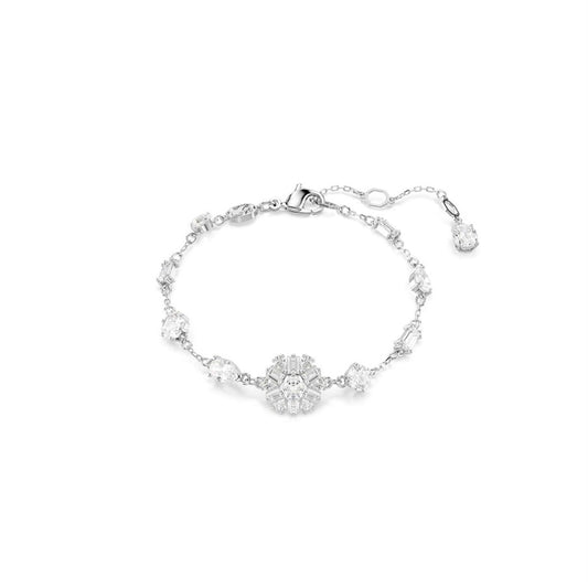 The Swaroavski Idyllia Bracelet by Swarovski is an elegant silver piece with a central floral motif adorned with sparkling white crystals, complemented by an adjustable, rhodium-plated band.