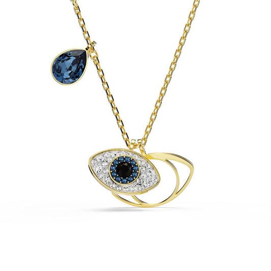 This gold-tone necklace, known as the Swarovski Symbolica Evil Eye Necklace Pendant, by Swarovski, features a distinctive eye design embellished with blue and white stones. A teardrop-shaped blue gem enhances its elegance, completing the contemporary look against a plain white background.