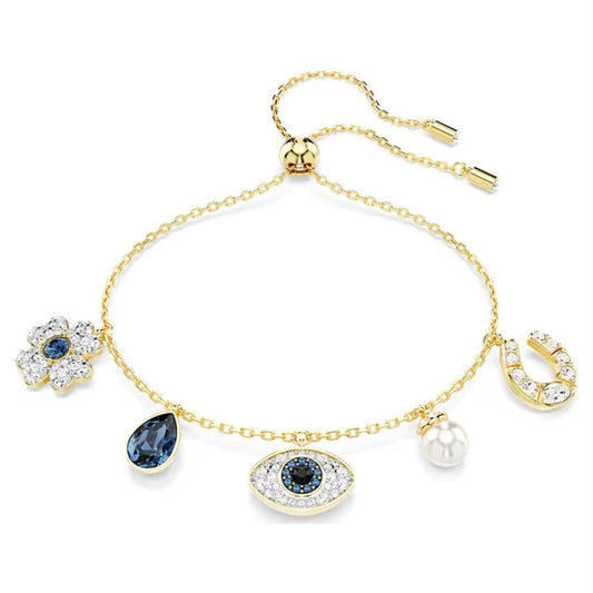 The Swarovski Symbolica Evil Eye Charm Bracelet by Swarovski is a stunning piece of symbolic jewelry adorned with charms including a flower, blue teardrop, evil eye, pearl, and horseshoe. Each charm is intricately detailed with sparkling gemstones and connected by a delicate chain featuring an adjustable clasp.