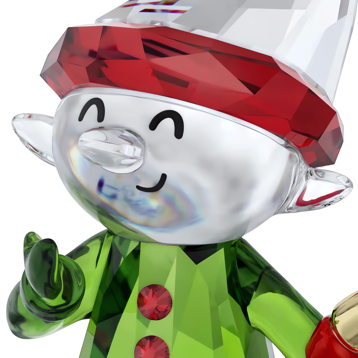 A close-up of the Swarovski Holiday Cheers Dulcis Elf and Candy Cane figurine by Swarovski—a sparkling glass elf with a red hat, green outfit accented by red buttons, and a joyful smile, hand raised and pointed forward—perfect as a festive ornament or holiday decoration.