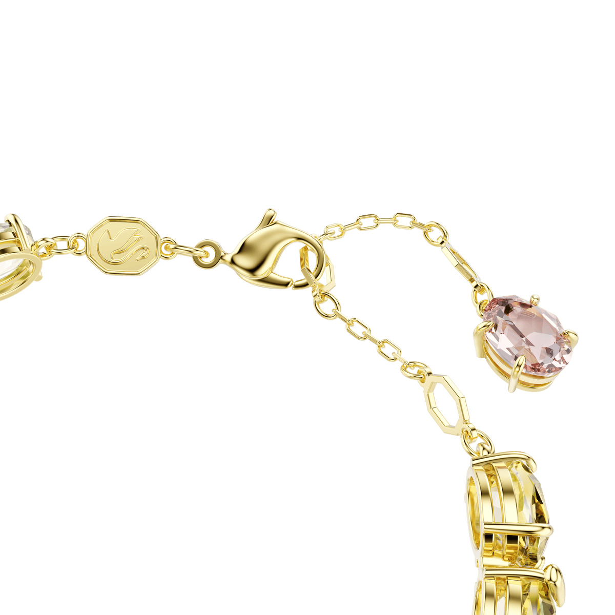 A close-up of the Swarovski Gema bracelet showcases its 18K gold finish, secure lobster clasp, adjustable chain, small octagonal tag accented with Swarovski branding, and a mix of multicolored gemstones in various cuts—including an oval pink gemstone set in a gold prong setting surrounded by vibrant crystals. The background is white.
