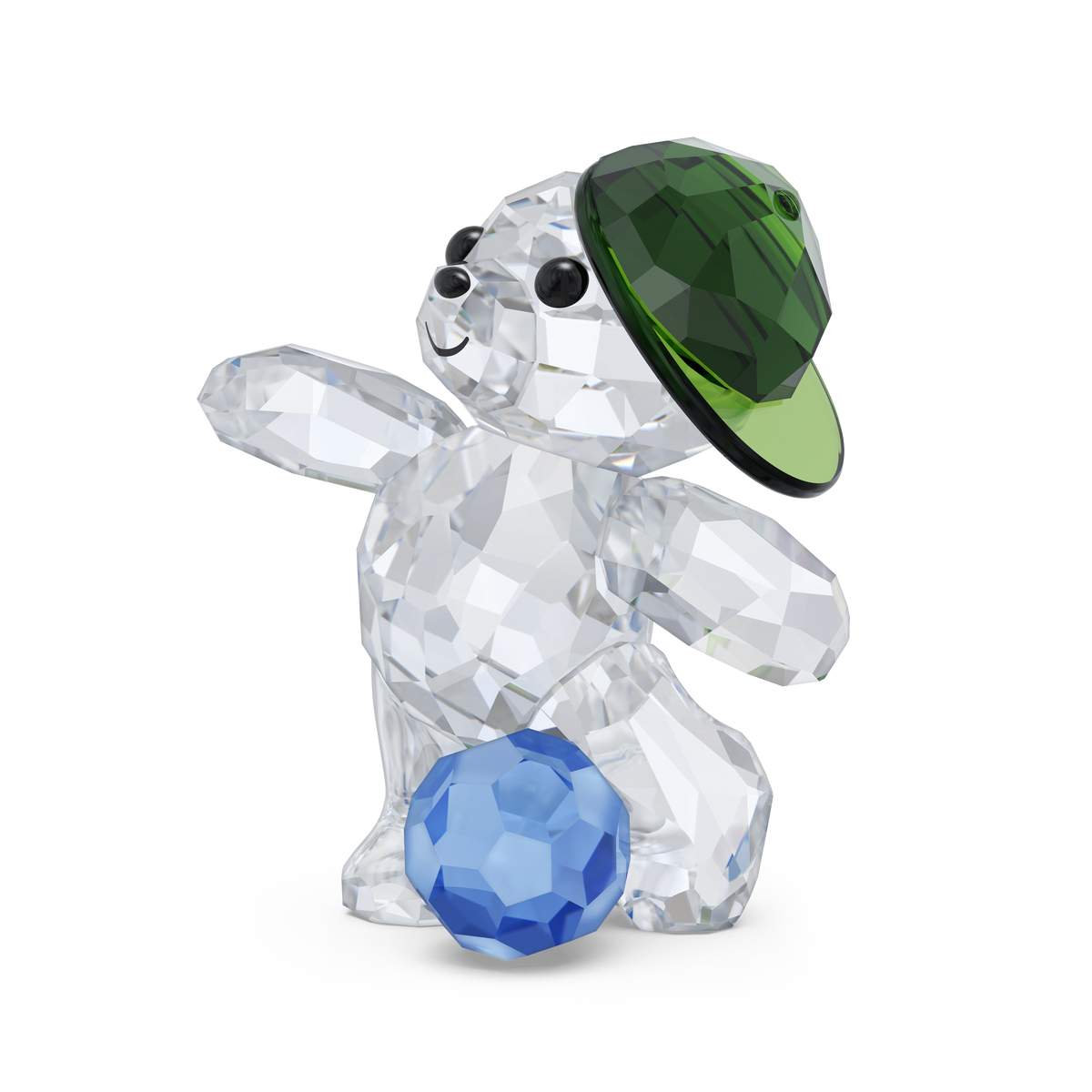 The Swarovski Kris Bear Goal Scorer Bear by Swarovski is a charming crystal collectible featuring a bear in a green cap, standing on its hind legs and balancing a blue crystal ball with one foot. With black eyes and a smiling expression, it makes an ideal sports gift or addition to any soccer-themed collection.