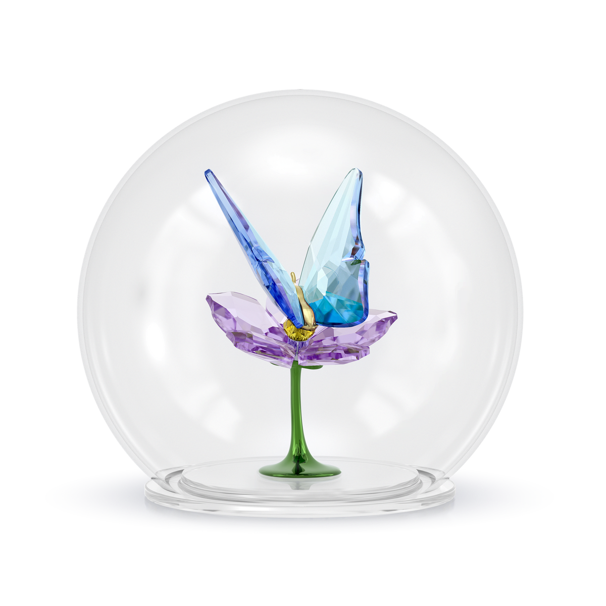The Swarovski Idyllia Glass Ball Butterfly and Flower figurine features a delicate butterfly with blue wings perched on a purple flower, set atop a green stem and encased in a clear glass dome. Displayed against a plain light background, this enchanting crystal creation beautifully showcases the artistry of Swarovski.