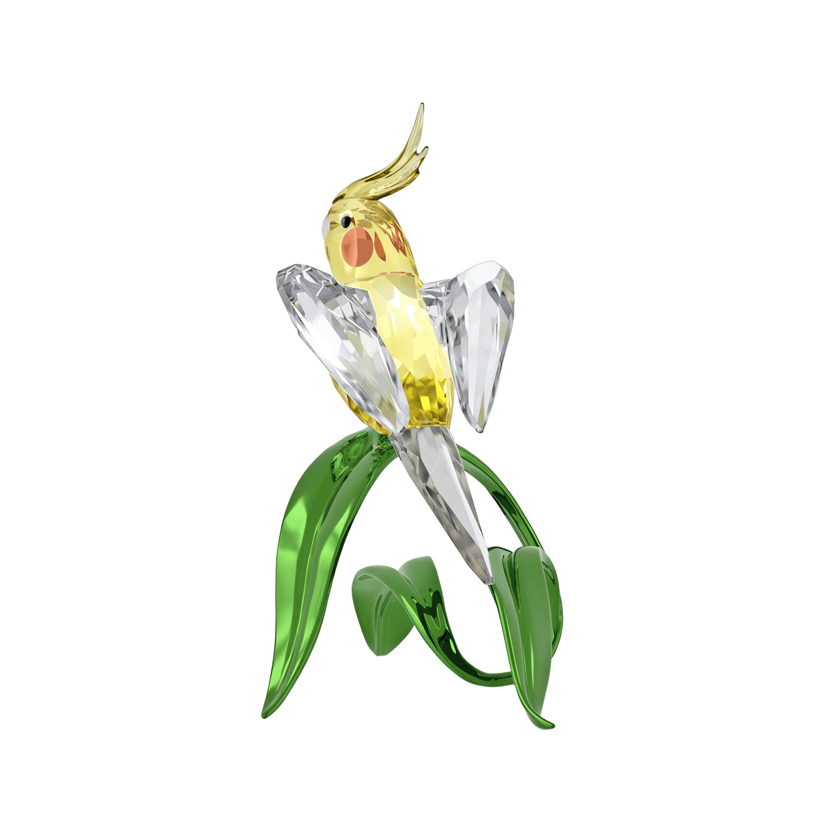 The Swarovski Idyllia Cockatiel by Swarovski is a crystal decoration featuring a yellow and clear cockatiel figurine with a gold crest, perched on a green crystal branch with leaves, all set against a plain white background.