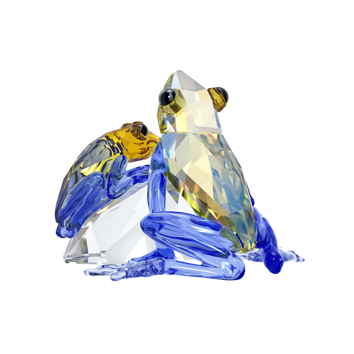 The Swarovski Idyllia Frog and Baby figurine by Swarovski features two crystal frogs—a larger one with blue, yellow, and clear facets and a smaller frog with yellow and blue accents—set against a simple, light background, symbolizing parental love while adding an elegant touch to any home décor.