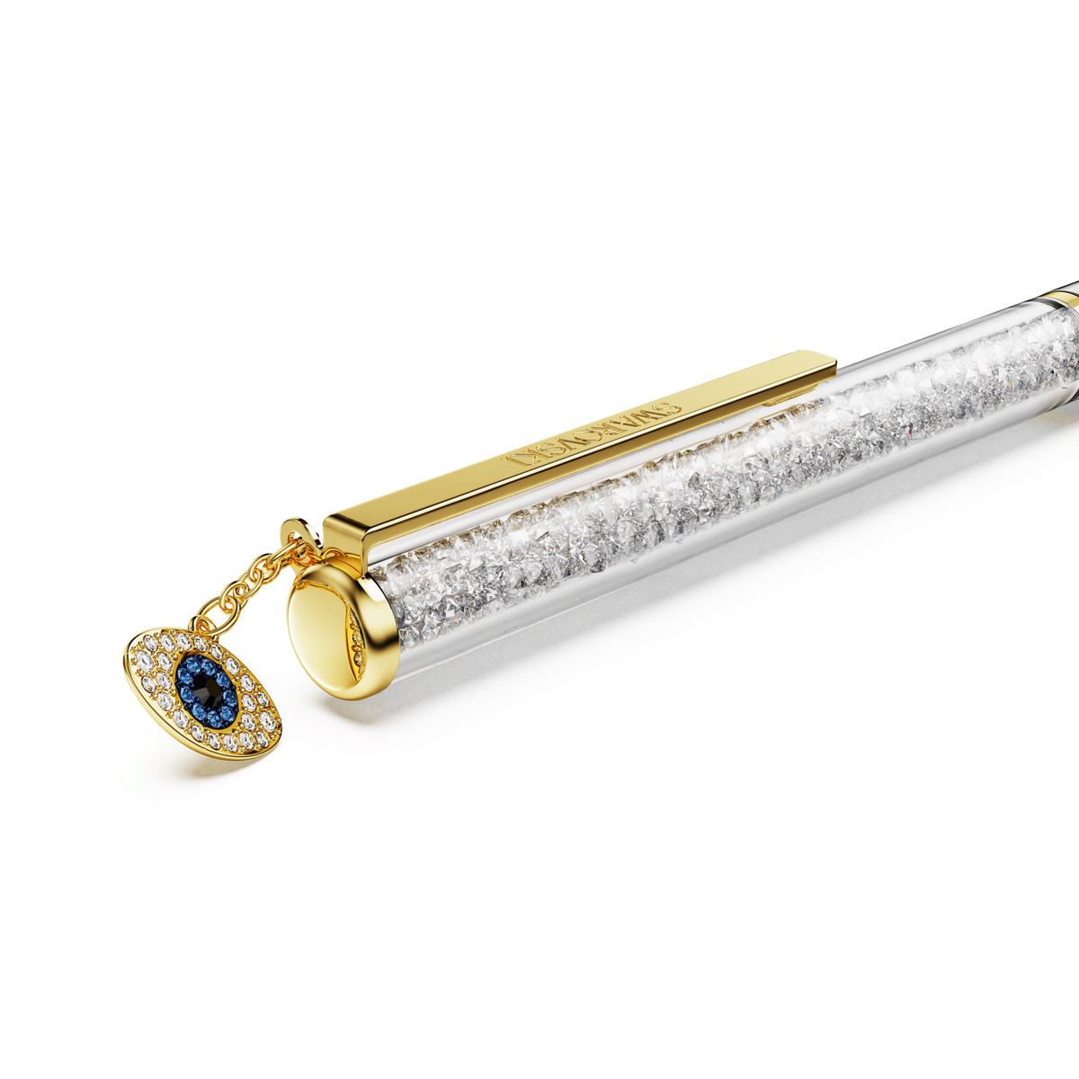 The Swarovski Crystalline ballpoint pen features a slim, clear barrel filled with sparkling crystals and is adorned with a gold- and blue-toned evil eye charm near the clip, showcasing Swarovski’s signature mixed metal finish.