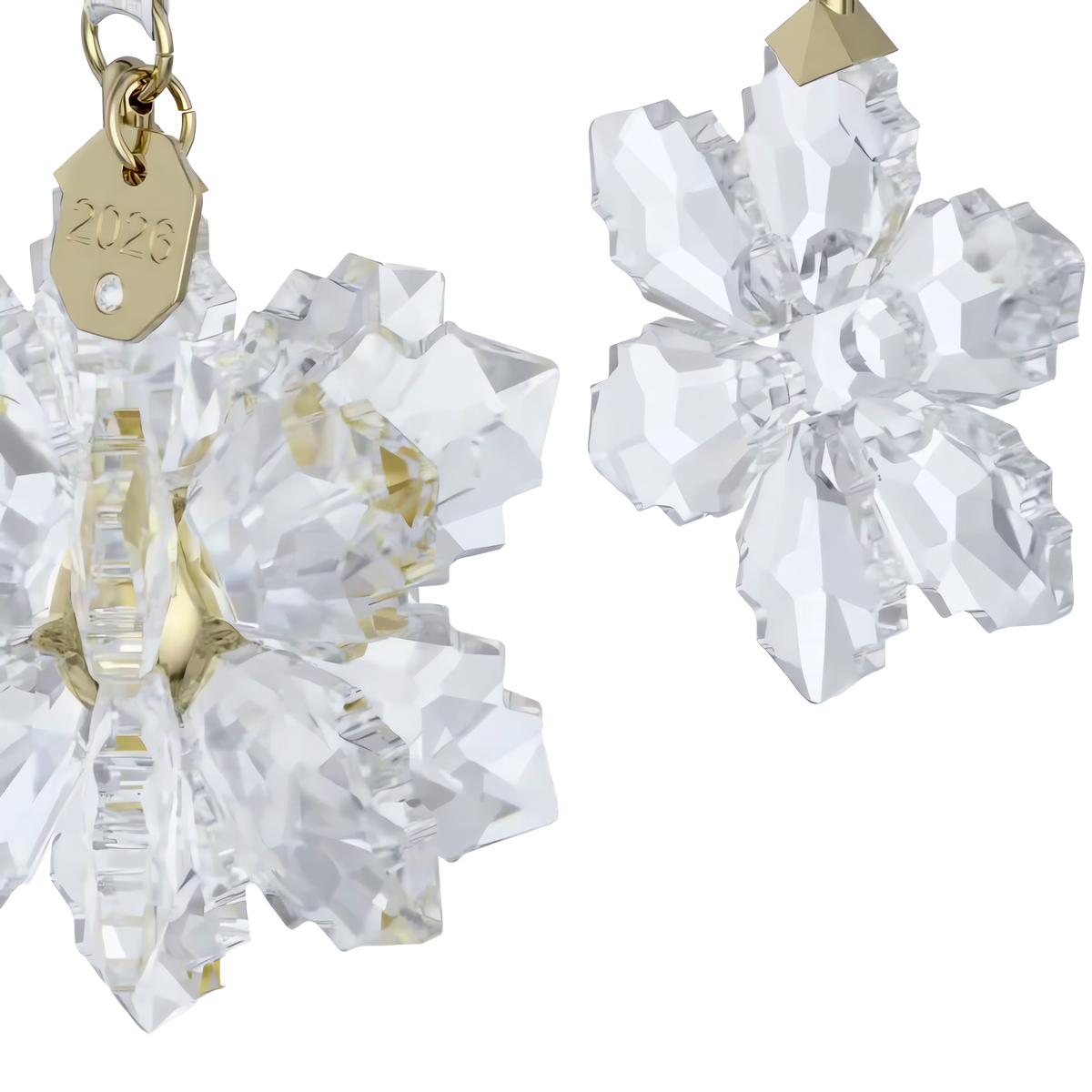 Two crystal snowflake ornaments with gold-tone metal accents—one adorned with a “2026” tag—displayed on a white background, from the elegant Swarovski Annual Edition 3D Ornament Set 2026.