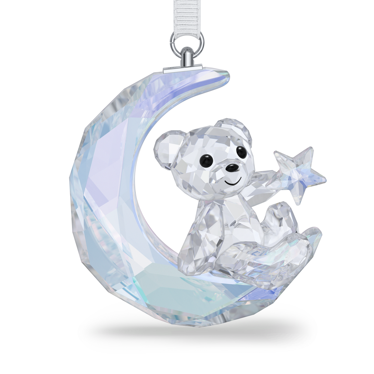 The Swarovski Kris Bear Moon Ornament features a charming Kris Bear holding a star while seated on a crescent moon, all exquisitely crafted from faceted clear and iridescent crystal by Swarovski. Complete with an attached ribbon for hanging, this stunning ornament is the perfect addition to your collection.