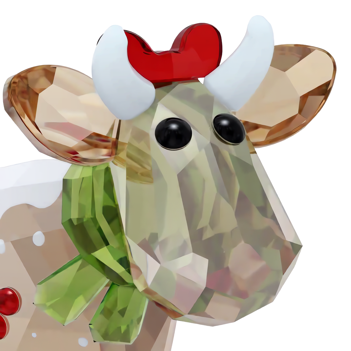 A close-up of the Swarovski Mo Holiday Annual Edition 2026, a faceted crystal cow figurine by Swarovski, featuring black eyes, white horns, a red bow on its head, and a green ribbon around its neck, set against a plain white background. This charming collectible decoration is perfect for celebrating the holidays.
